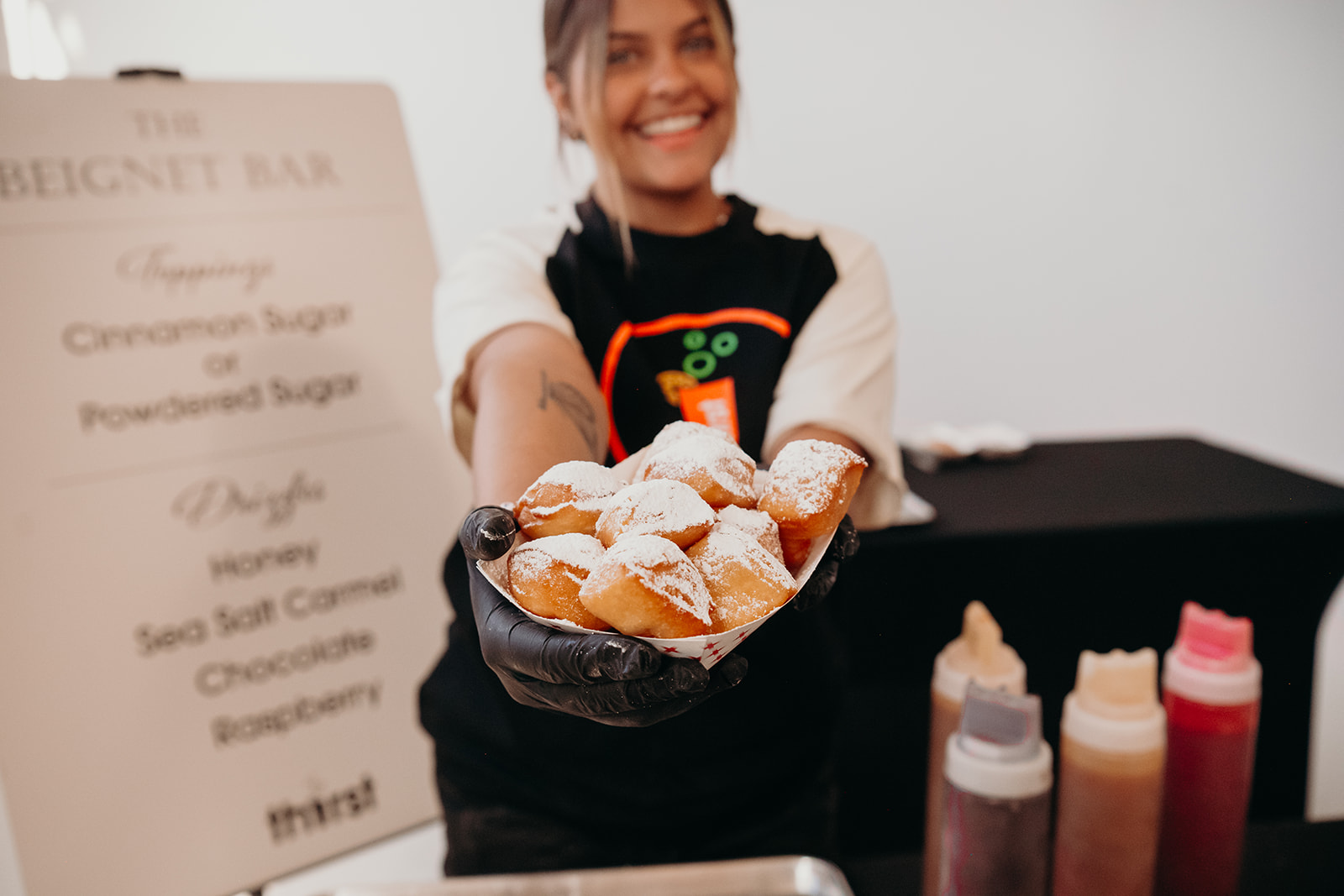 A Thirst team member serving fresh beignets at a wedding reception