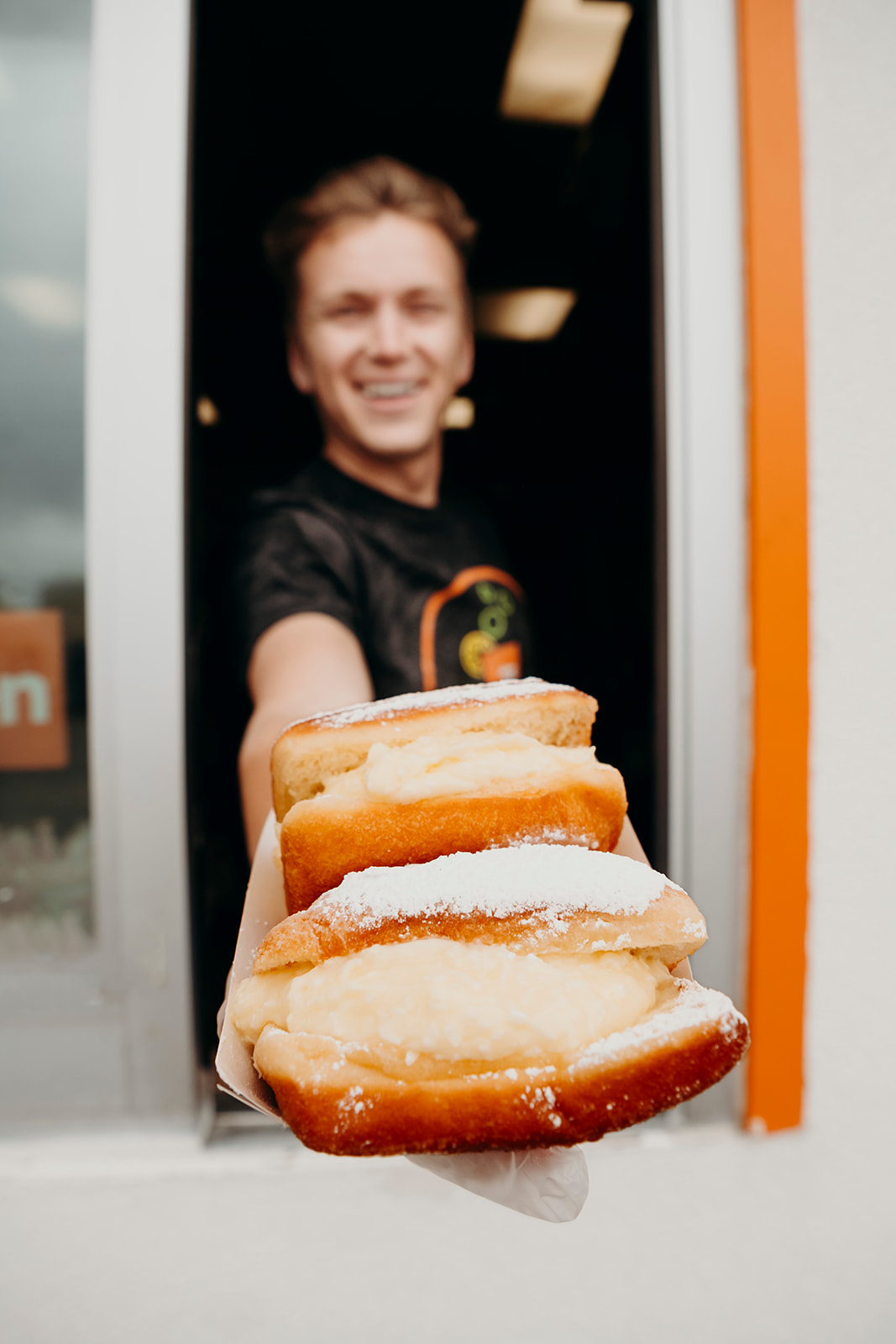 Ethan handing beignets out the drive-thru window