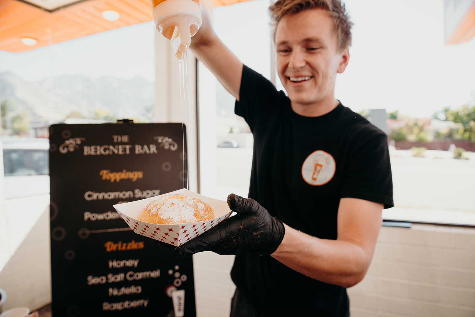A beignet getting a fresh drizzle