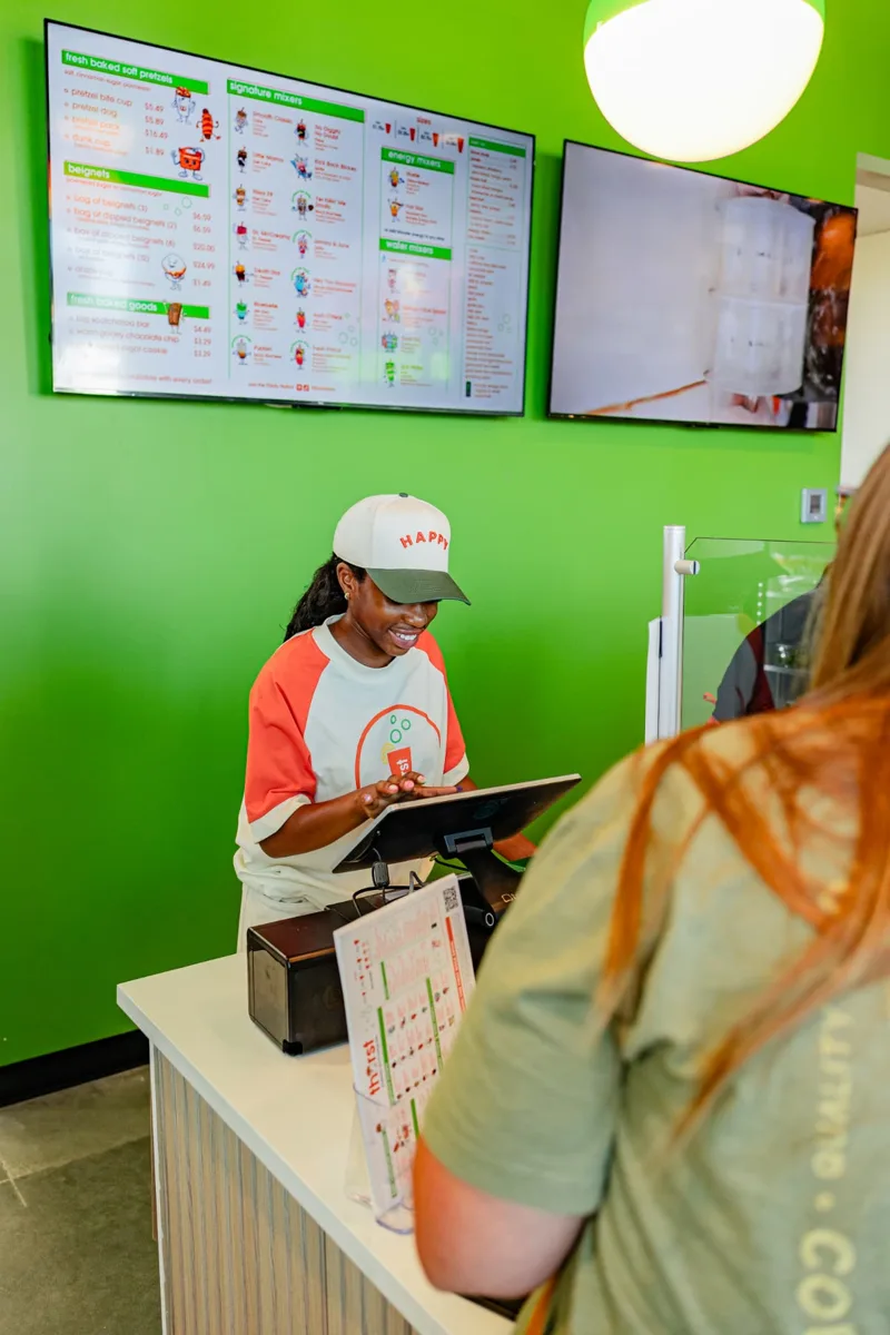 Smiling Thirst team member taking an order