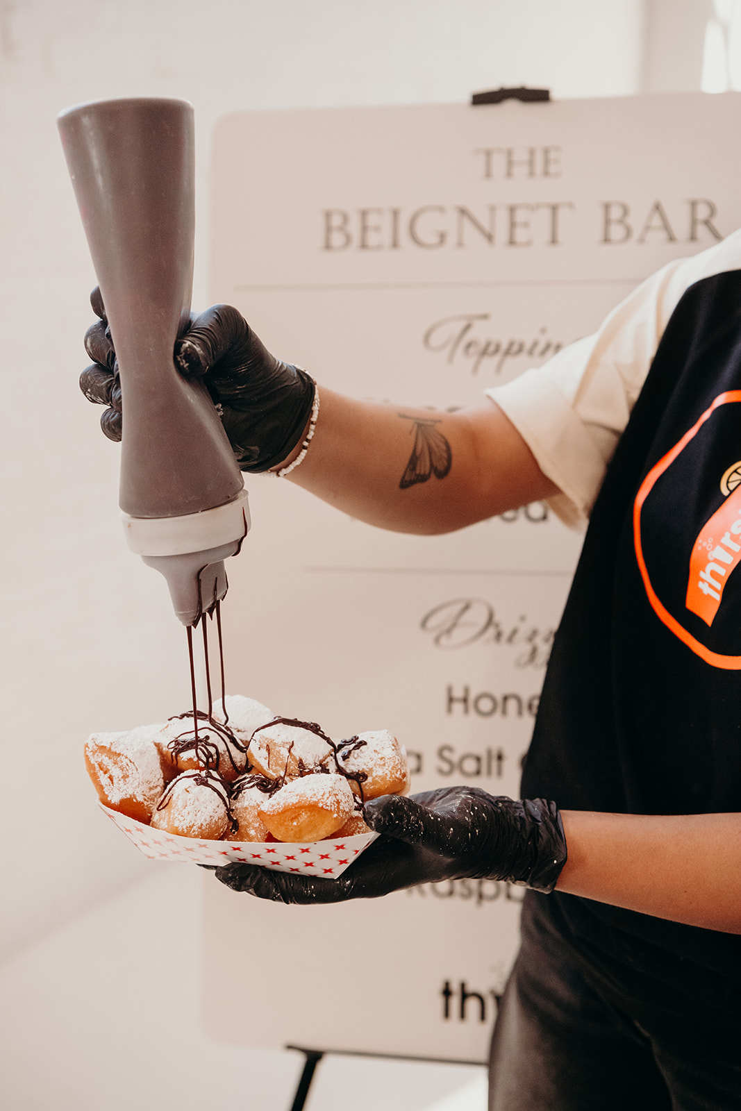 Chocolate being drizzled over fresh beignets at the Beignet Bar