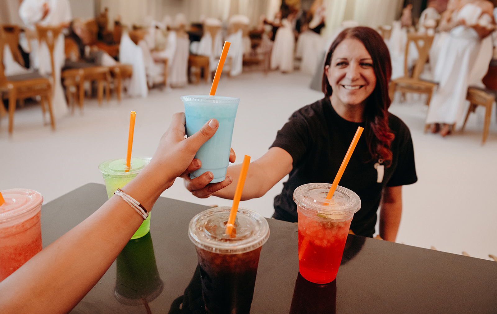 A Thirst team member handing a dirty soda to a guest at a Utah wedding reception