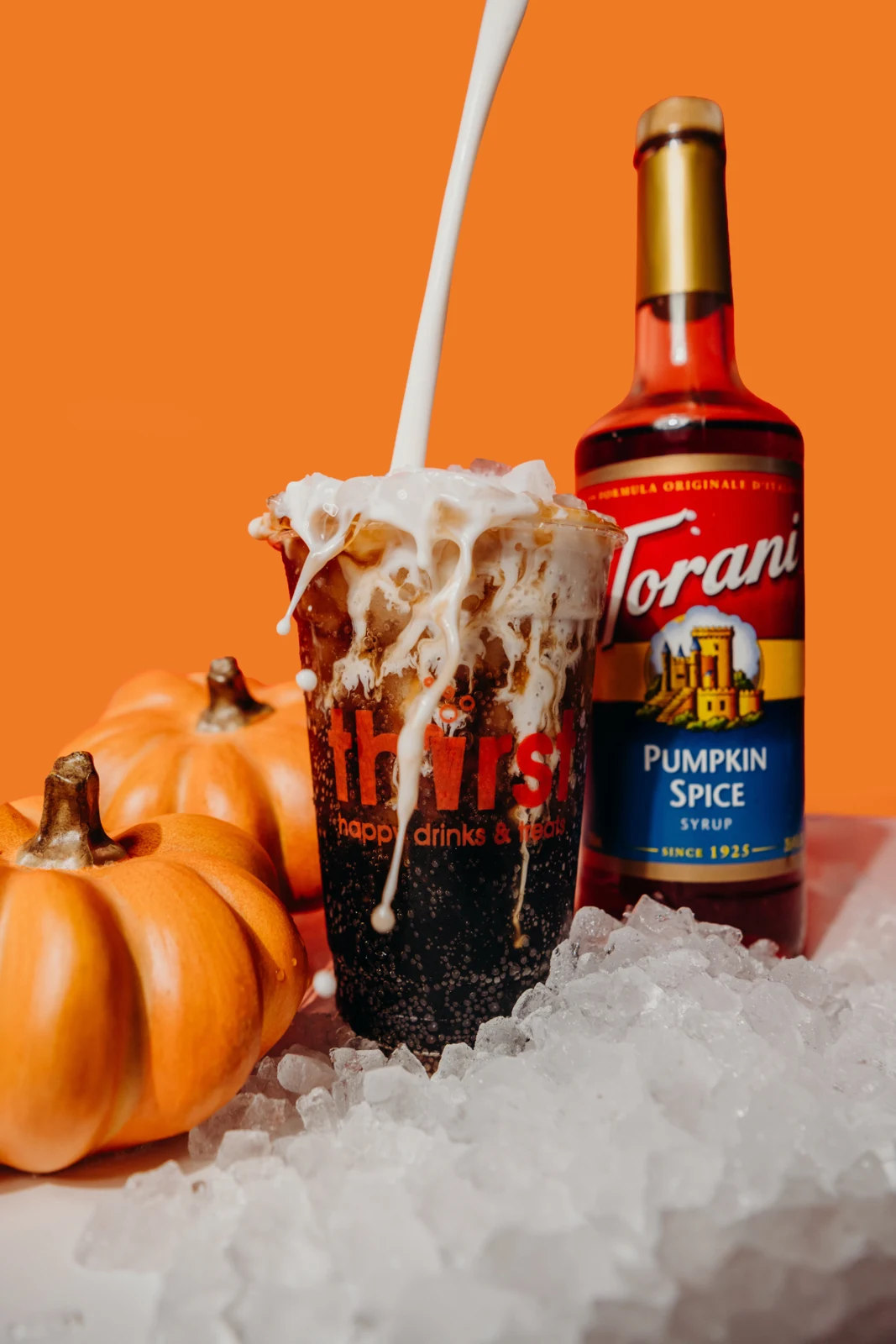 Pumpkin Spice DP — Dr. Pepper with pumpkin spice syrup and vanilla cream, beside a Torani Pumpkin Spice syrup bottle and pumpkins