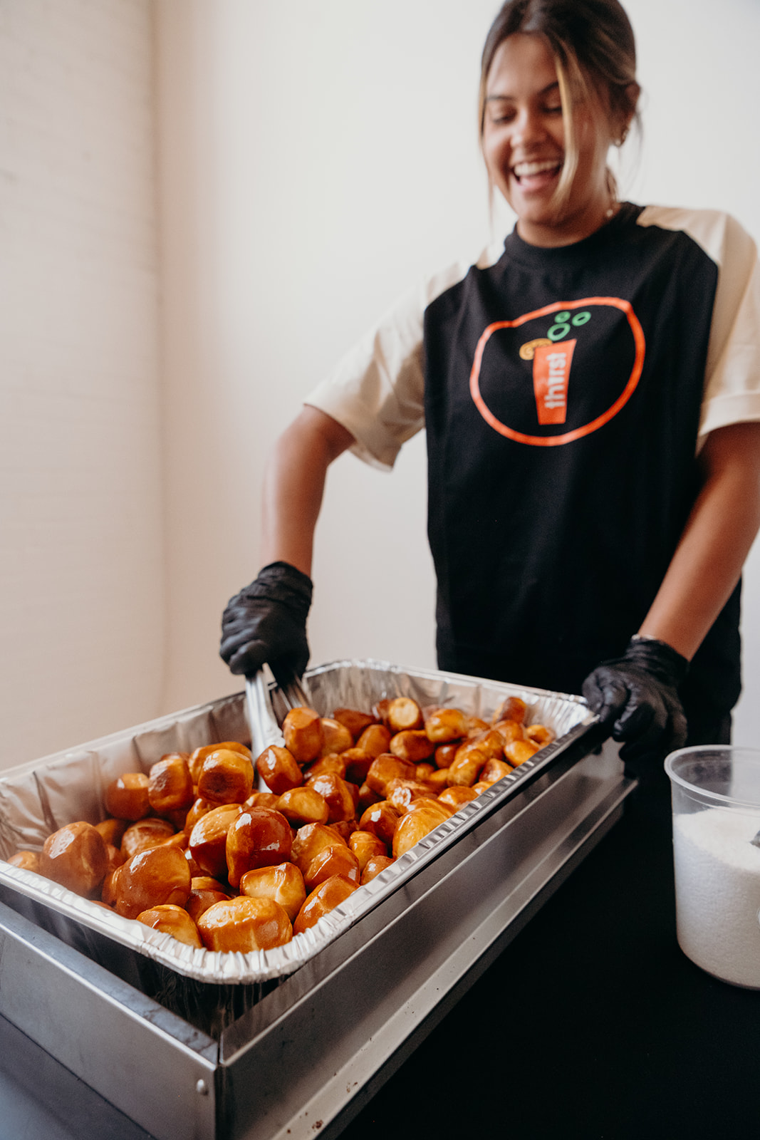 A Thirst team member serving warm pretzel bites from a catering tray at a school event